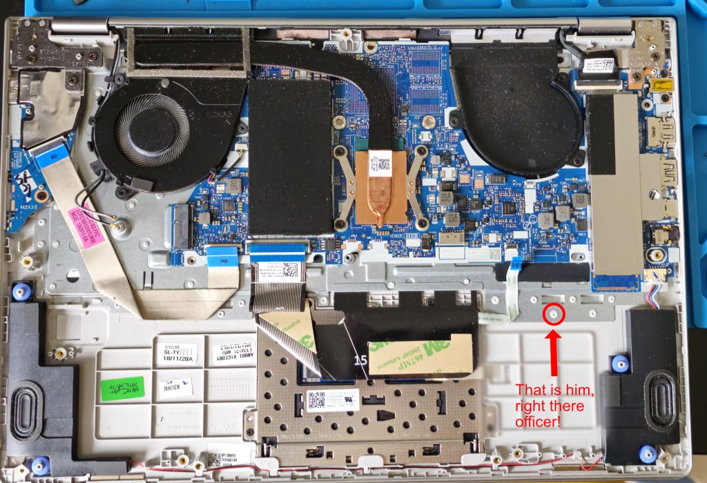 An image of the laptop with the battery taken out, It shows the motherboard and a number of plastic pegs. An arrow points to one peg with the caption "That is him, right there officer!"