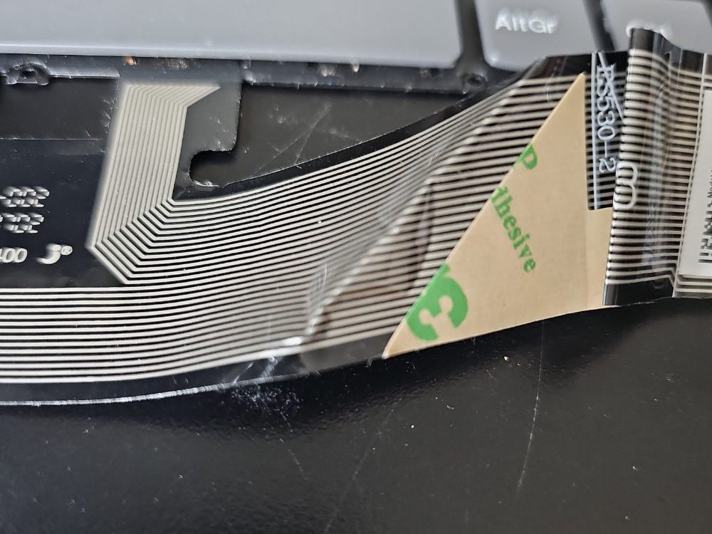 The crease in the ribbon cable of the keybaord